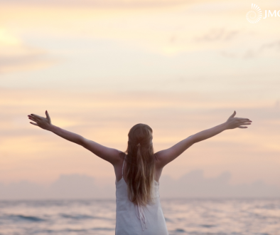 woman standing in front of ocean feeling free